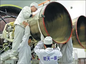  ??  ?? Workers from the China Academy of Launch Vehicle Technology check a Long March 3A rocket.