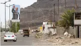  ??  ?? ADEN: Photo shows cars driving beneath a large billboard showing Yemen’s internatio­nally recognized government of President Abedrabbo Mansour Hadi, along a road in Yemen’s second city of Aden. —AFP