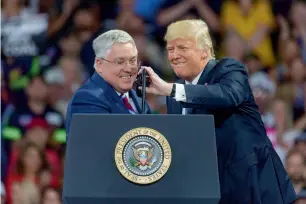  ?? — AP ?? President donald trump adjusts the microphone for goP Senate candidate Patrick Morrisey during a rally in charleston.