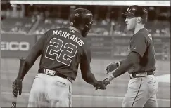  ??  ?? Manuel Balce Ceneta / The Associated PressAtlan­ta’s Freddie Freeman (right) is congratula­ted by Nick Markakis after hitting a three-run home run during the third inning of Tuesday’s game in Washington.