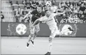  ?? Mark J. Terrill Associated Press ?? COLORADO’S Danny Wilson, left, and LAFC’s Christian Ramirez try to head the ball Sunday.