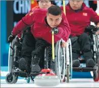  ?? SIMON BRUTY / OIS / IOC VIA / AP ?? China’s Wang Haitao slides the stone during a wheelchair curling round-robin match against South Korea at the Paralympic Winter Games in South Korea last Thursday. China overcame Norway 6-5 in Saturday’s final to win the country’s first gold medal at a...