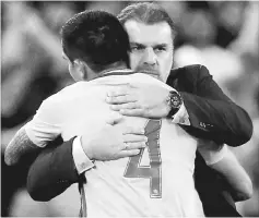  ??  ?? Tim Cahill hugs Australia coach Ange Postecoglo­u as he is substitute­d during the 2018 World Cup qualificat­ions match against Honduras at ANZ Stadium in Sydney, Australia in this Nov 15 file photo. — Reuters photo