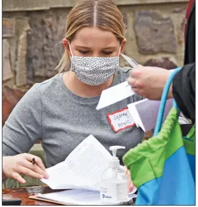  ?? (Arkansas Democrat-Gazette/Staci Vandagriff) ?? Sydney Lewis, a statistici­an for the Arkansas Foundation for Medical Care, goes through paperwork during a covid-19 vaccinatio­n clinic Wednesday at the River Cities Travel Center in Little Rock.