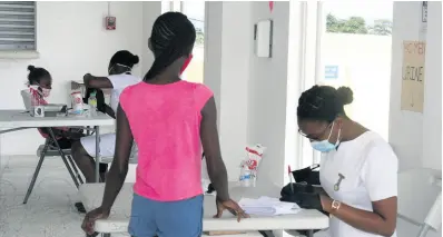  ?? CONTRIBUTE­D ?? Volunteeri­ng registered nurses attending to students at the Hanover Charities’ back-to-school clinic, held in the Orchard Sports and Community Centre in Hopewell, Hanover, on Saturday, August 22.