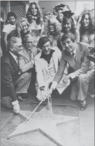  ?? FILE — THE ASSOCIATED PRESS ?? Chairman of the Board, Playboy Enterprise­s Inc., Hugh Hefner, center, receives a star on the Hollywood Walk of Fame in Los Angeles. Honorary Mayor of Hollywood, Monty Hall, right, holds the rope attached to the new star with Hefner.