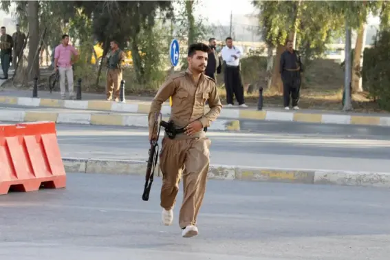  ??  ?? A member of the Kurdish Peshmerga force runs during the Isis attack on Kirkuk (Reuters)
