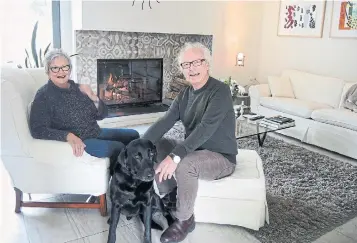  ?? KEITH BRANSCOMBE ?? Left: “What I like most about the house is its comfortabl­e modern usefulness,” saysAcomba, with his wife, Sharon Keogh, and dog, Chester. Acomba designed the living room with a fireplace and roll-away TV.