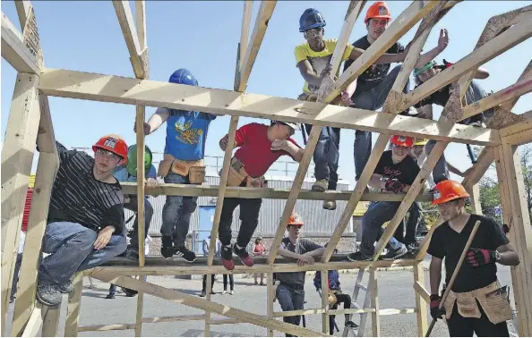  ?? ED KAISER ?? Students atop an unfinished greenhouse at a two-week constructi­on camp on Wednesday, learning framing, roofing and glass installati­on.