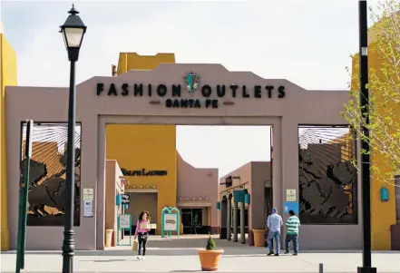  ?? ASHLEY HERNANDEZ/FOR THE NEW MEXICAN ?? A smattering of people walk through the front entrance of the nearly deserted Fashion Outlets Santa Fe on April 16. More than half of the locations at the outlet mall, which is in foreclosur­e, are empty.