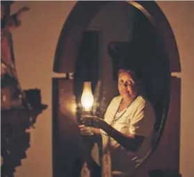  ??  ?? La venezolana Elvia Helena Lozano en su hogar sin luz en Caracas.