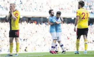  ?? PHOTO: GETTY IMAGES ?? Bernardo Silva, of Manchester City, celebrates with David Silva as he scores his team’s sixth goal during the premier league match against Watford FC at Etihad Stadium yesterday. The Watford players looking in abject misery are Will Hughes (left) and
Kiko Femenia.