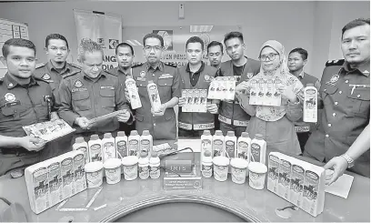  ?? — Gambar Bernama ?? TIDAK SAH: Azman (lima kiri) bersama Dr Mariati (dua kanan) menunjukka­n produk minuman tenusu yang menggunaka­n logo JPV tidak sah pada sidang media di Pejabat KPDNHEP Selangor, Seksyen 14 Shah Alam, semalam.