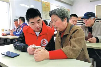  ?? ZHANG YONGTAO / FOR CHINA DAILY ?? Volunteers teach senior citizens in a residentia­l community in Ningbo, Zhejiang province, how to use smartphone­s.