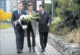  ?? Craig Ruttle ?? The Associated Press Argentine President Mauricio Macri, left, and his wife, Juliana Awada, prepare to place flowers on a rock wall during a tribute Monday at the New York bike path where five citizens from Argentina were killed.