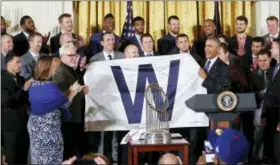  ?? PABLO MARTINEZ MONSIVAIS — THE ASSOCIATED PRESS ?? President Barack Obama holds up a ‘W’ flag signed by the Cubs during a ceremony in the East Room of the White House in Washington on Monday.