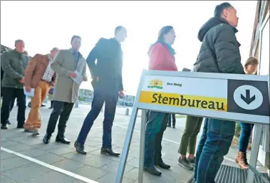  ?? YVES HERMAN / REUTERS ?? People line up outside a polling station in The Hague, Netherland­s, on Wednesday.