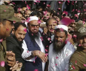  ?? PHOTO/K.M. CHAUDARY ?? In this Oct. 19, 2017 file photo, supporters of Hafiz Saeed (center) head of the Pakistani religious party, Jamaat-udDawa, is showered with rose petals by his supporters as he arrives to a court in Lahore, Pakistan. AP