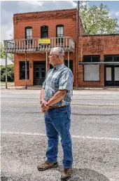  ?? Sharon Joines ?? Tom Joines, who grew up in Glen Flora, remembers when the little town was livelier. He is in front of the two-story brick building that was Scheller’s Place for many years.