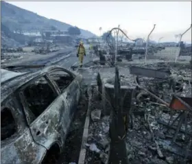  ?? GREGORY BULL — THE ASSOCIATED PRESS ?? Fire crews search for hot spots among destroyed homes in the Rancho Monserate Country Club community Friday in Fallbrook The wind-swept blazes have forced tens of thousands of evacuation­s and destroyed dozens of homes in Southern California.