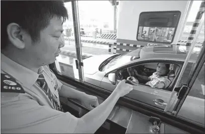  ?? PHOTOS PROVIDED TO CHINA DAILY ?? A toll man collects highway fees in Ningbo, Zhejiang province, by scanning the QR code, which is a leading way of mobile payment in China.