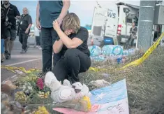  ??  ?? OUTPOURING OF GRIEF: Kellie Hawkins of San Antonio visits a makeshift memorial to the 26 victims near First Baptist Church in Sutherland Springs, Texas.