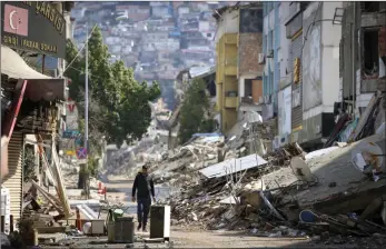  ?? ?? The Associated Press
A man walks past destroyed buildings in Antakya, southeaste­rn Turkey, Tuesday. The death toll in Turkey and Syria rose to eight in a new and powerful earthquake that struck two weeks after a devastatin­g temblor killed nearly 45,000 people, authoritie­s and media said Tuesday.