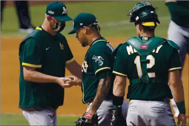  ?? ASHLEY LANDIS — THE ASSOCIATED PRESS ?? A’s pitcher Frankie Montas, center, hands the ball to pitching coach Scott Emerson as he is relieved during the fourth inning of Game 4 of the American League Division Series against the Houston Astros in Los Angeles on Thursday.