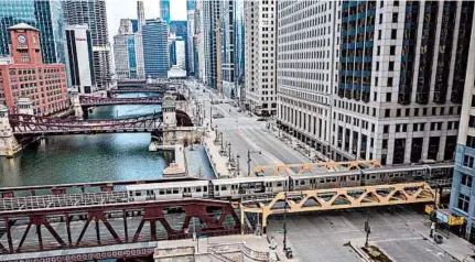  ?? ZBIGNIEW BZDAK/CHICAGO TRIBUNE ?? A train crosses an empty intersecti­on at the Chicago River on March 24. City streets all over the nation have gone quiet as citizens selfquaran­tine. Talk to your children about what “normal” means now, and how it will change.