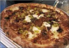  ?? PHOTOS BY MARK MESZOROS — THE NEWS-HERALD ?? The BBQ Pork is one of nearly 20 pizza choices at Masthead Brewing Co.