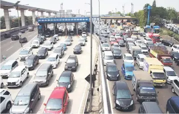  ??  ?? Commuters make a long line on a highway in Jakarta with the under constructi­on sky-train line being prepared to solve the traffic problem. Developing Asia is on track to grow faster this year and next, the Asian Developmen­t Bank said yesterday, buoyed...