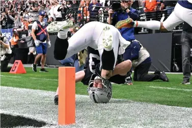  ?? AP Photo/David Becker ?? ■ Las Vegas Raiders wide receiver Hunter Renfrow (13) flips over after catching a pass for a touchdown against the Denver Broncos during the first half Sunday in Las Vegas.