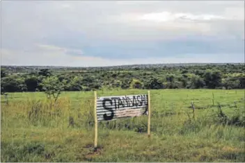  ??  ?? Illegal advertisin­g: Members of the Mmotoaneng community have applied paint to a board advertisin­g the sale of their land in a bid to curb the practise