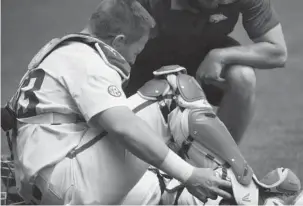  ?? NWA Democrat-Gazette/J.T. Wampler ?? CATCHER DOWN: Arkansas junior catcher Grant Koch holds his ankle Sunday after sustaining a leg injury Sunday during the Razorbacks’ 6-3 win against Texas A&M.