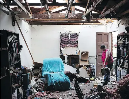  ?? JOE RAEDLE / GETTY IMAGES ?? Amanda Logsdon begins the task of cleaning her home after the roof was blown off by Hurricane Michael in Panama City, Florida.