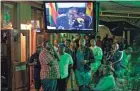  ?? BEN CURTIS/AP ?? Disappoint­ed Zimbabwean­s watch a televised address by President Robert Mugabe in downtown Harare, Zimbabwe, on Sunday.