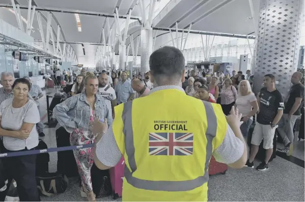  ??  ?? 0 A British government official speaks to tourists flying with Thomas Cook as they queue at the Enfidha Internatio­nal Airport in Tunisia
