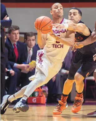  ?? DON PETERSON/THE ASSOCIATED PRESS ?? Miami’s Angel Rodriguez reaches in to thwart Virginia Tech’s Justin Robinson, front, during the first half of Saturday’s game in Blacksburg, Va.