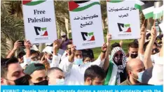  ?? — Photo by Yasser Al-Zayyat ?? KUWAIT: People hold up placards during a protest in solidarity with the Palestinia­n people at the Iradah Square in Kuwait City yesterday.