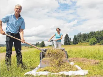  ?? FOTO: REGINA BRAUNGART ?? Jochen Kübler und Claudia Huesmann holen die auf einer Böttinger Wiese geernteten Pflanzensa­men aus dem „E-Beetle“.