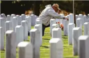  ?? Drew Angerer / Getty Images ?? VIRGINIA: A man visits Arlington National Cemetery’s section for those killed in Afghanista­n and Iraq.