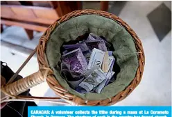  ?? —AFP ?? CARACAS: A volunteer collects the tithe during a mass at La Coromoto Church, in Caracas. The shortage of cash in the country has forced churches to accept ‘plastic money’ for the tithe.