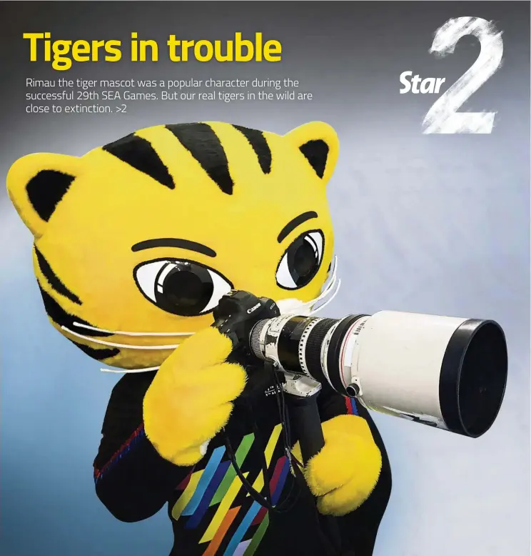  ?? — IZZRAFIQ ALIAS/The Star ?? Rimau, the tiger mascot for the SEA Games (as well as the upcoming 9th Asean Para Games) posing with a camera at the National Velodrome in Nilai, Negri Sembilan.