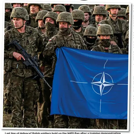  ?? ?? Last line of defence? Polish soldiers hold up the NATO flag after a training demonstrat­ion