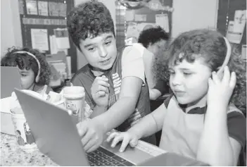  ?? JOHN MCCALL/SOUTH FLORIDA SUN SENTINEL ?? Christophe­r Dominguez helps his sister Kyrie with homework at their home.