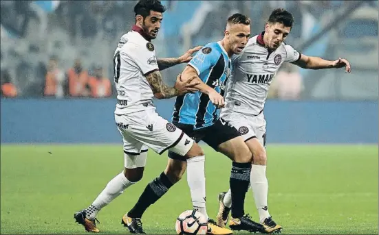  ?? BUDA MENDES / GETTY ?? Arthur, en el centro, lucha por un balón con dos jugadores del Lanús en la última final de la Copa Libertador­es, que el Gremio ganó