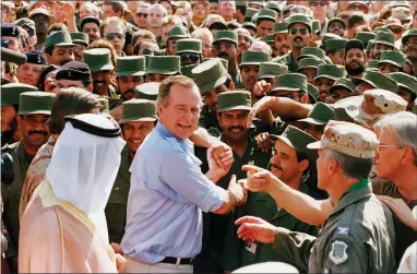  ?? AP FILE PHOTO BY J. SCOTT APPLEWHITE ?? In this Nov. 22, 1990 file photo, President George H.W. Bush is greeted by Saudi troops and others as he arrives in Dhahran, Saudi Arabia, for a Thanksgivi­ng visit. Bush died at the age of 94 on Friday, Nov. 30 about eight months after the death of his wife, Barbara Bush.