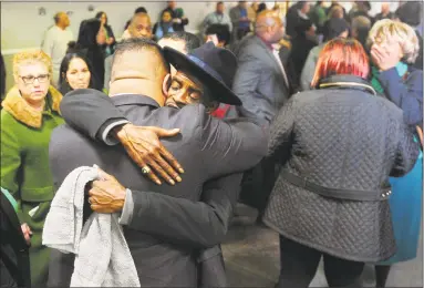  ?? Ned Gerard / Hearst Connecticu­t Media ?? State Rep. Chris Rosario and Bridgeport City Councilman Ernie Newton embrace prior to a moment of silence in memory of state Rep. Ezequiel Santiago at the Morton Government Center in Bridgeport on Friday. Santiago died overnight at the age of 45.