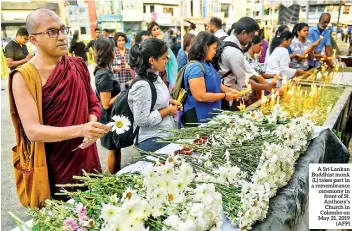  ??  ?? A Sri Lankan Buddhist monk (L) takes part in a remembranc­e ceremony in front of St. Anthony’s Church in Colombo on May 21, 2019 (AFP)