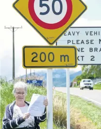  ?? PHOTO: RICHARD DAVISON ?? Slower progress . . . West Otago Community Board chairwoman Barbara Hanna holds a letter from the NZ Transport Agency yesterday, announcing 50kmh speed signs at Tapanui’s State Highway 90 Gore exit will be moved permanentl­y 200m further out in December.